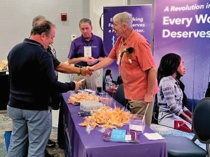 People visiting an exhibitor booth