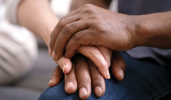 Hands holding someone else's hand in comfort